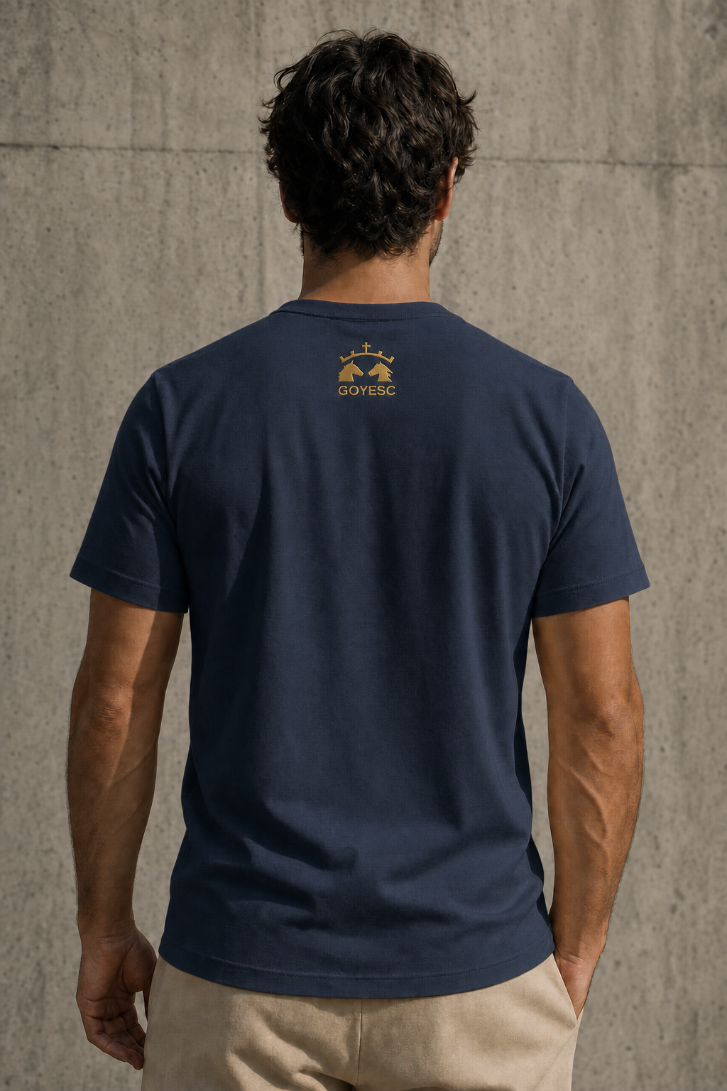 Espalda de la camiseta GOYESC en color azul marino, con logo dorado en la nuca